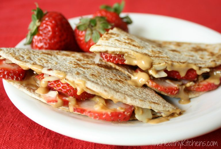 Strawberry and peanut butter quesadillas on a white plate.