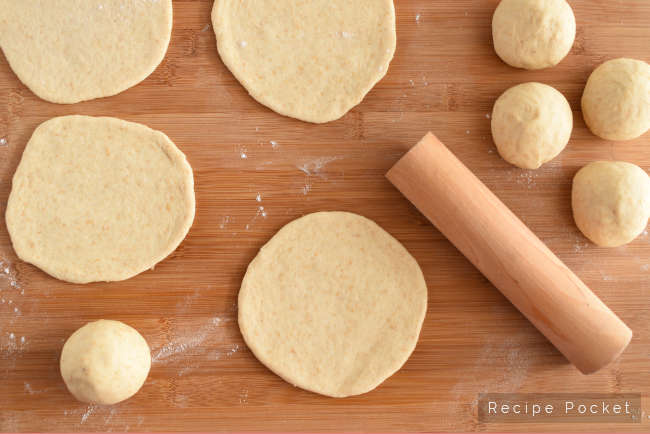 Image showing pita bread dough ball being rolled out.