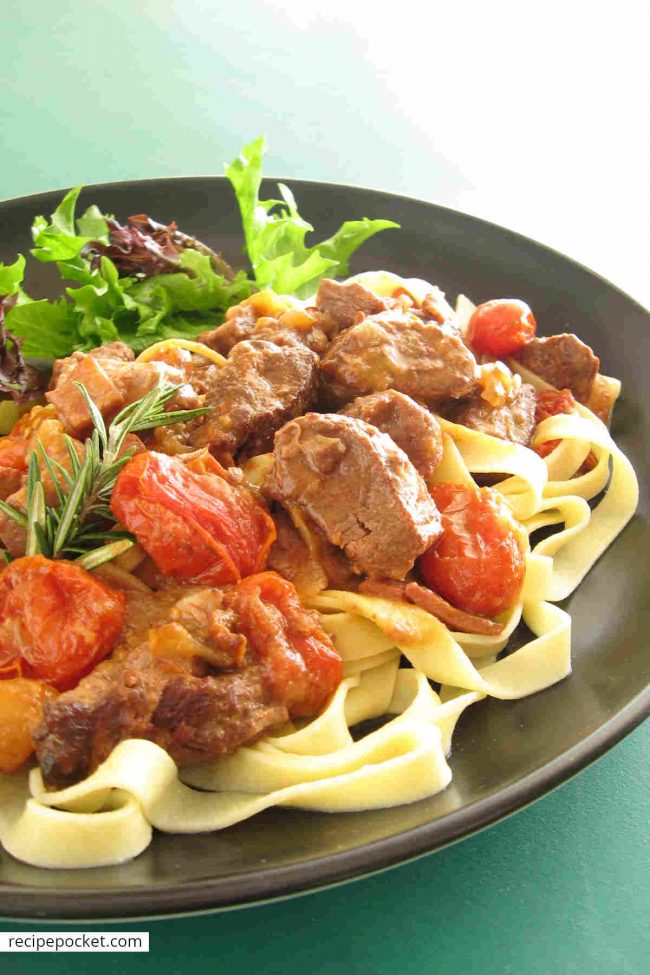 Lamb in red wine sauce with cherry tomatoes.