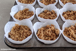 Uncooked muffins with crumble topping.