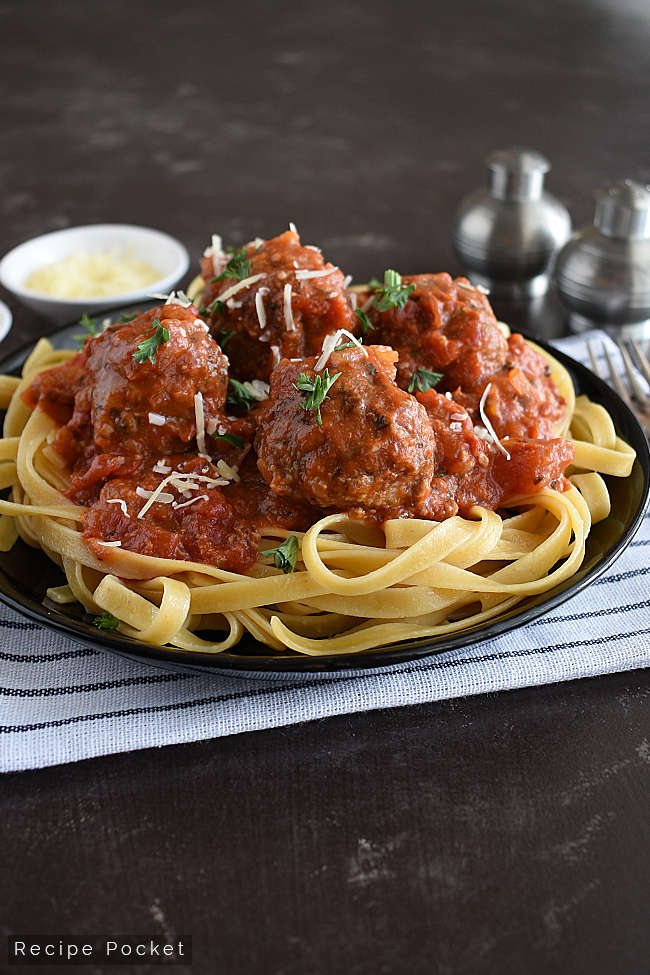 Meatballs in tomato sauce served on a bed of pasta.