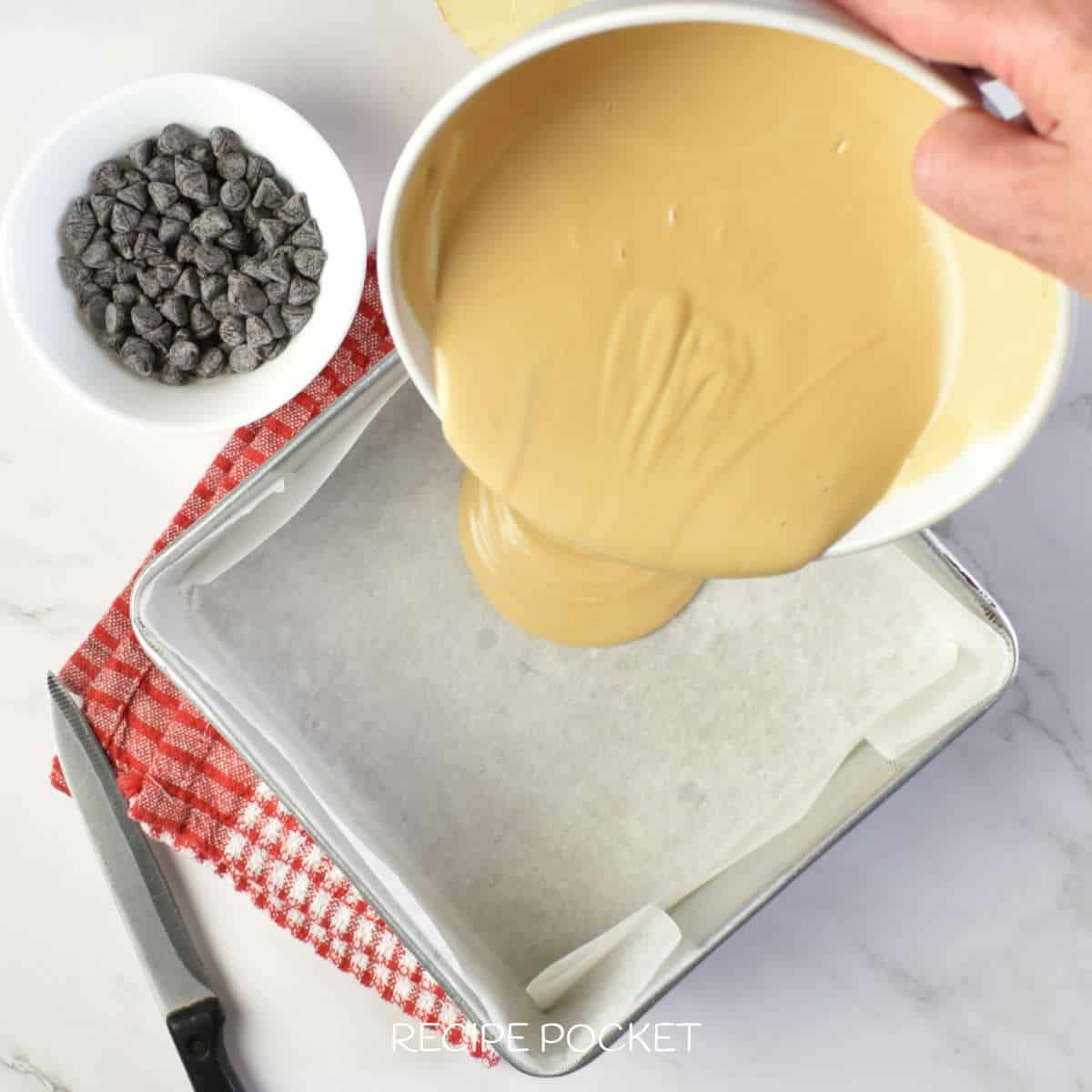 Fudge mixture being placed into a tin.