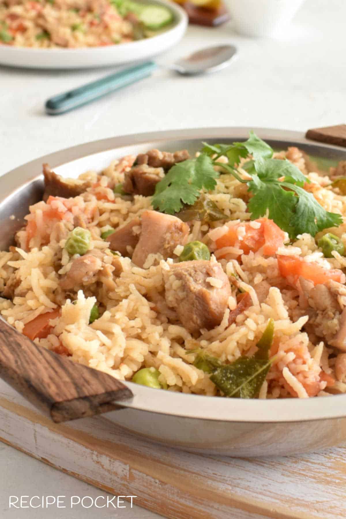 A close up of chicken and rice in a serving bowl.
