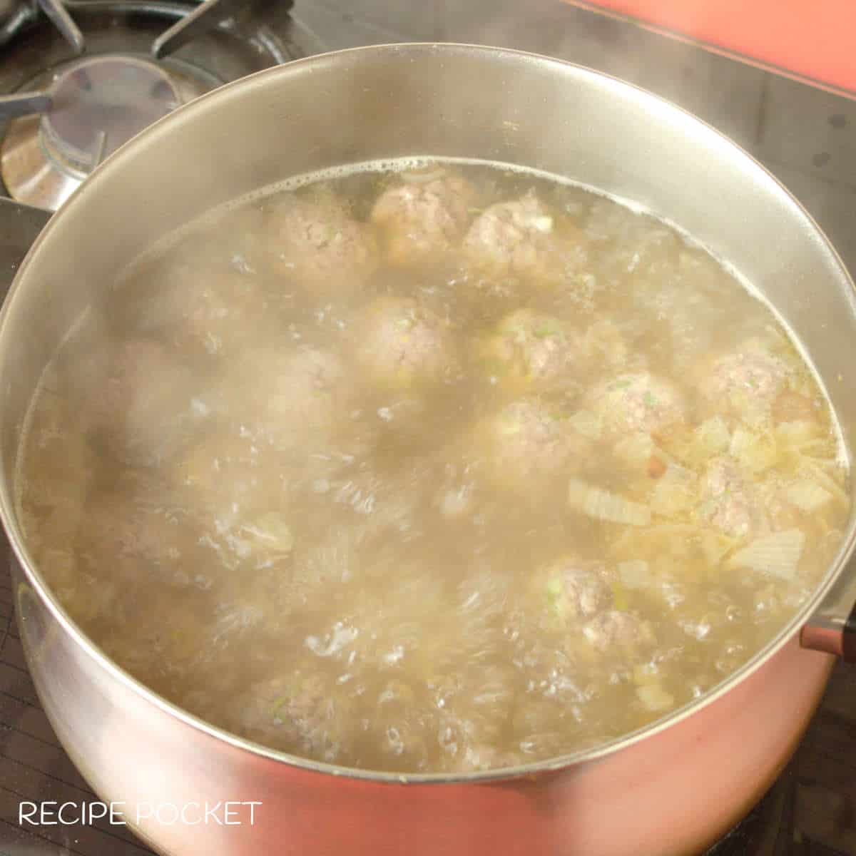 Meat balls simmering in soup.