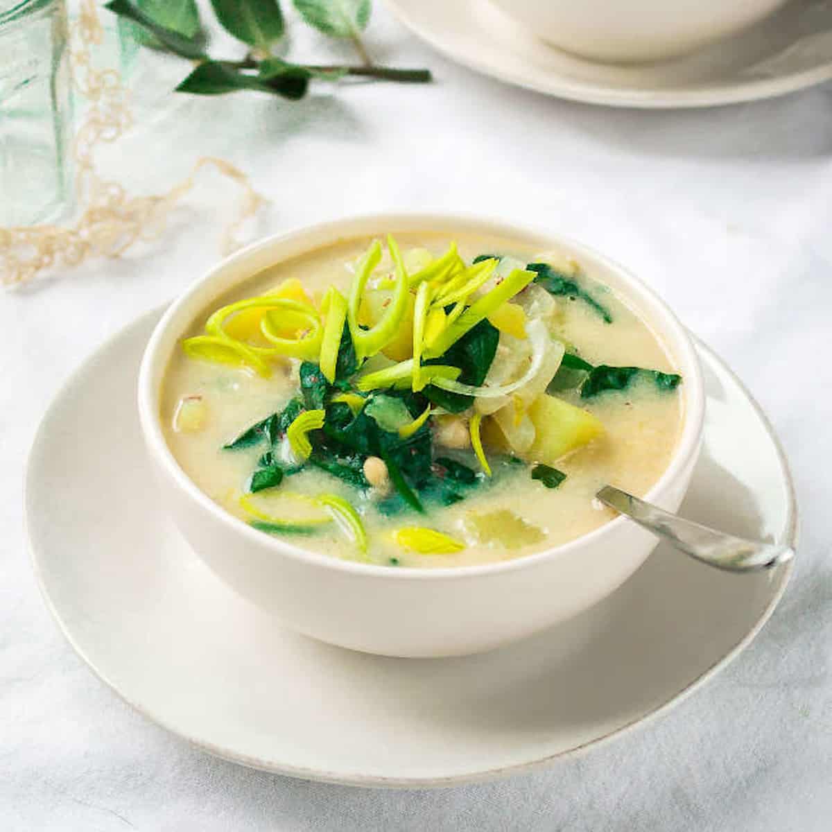 Bean and potato soup in white soup bowls.