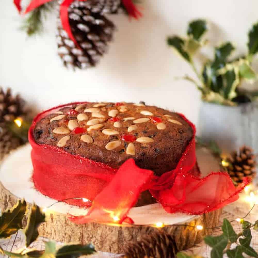 Fruit cake decorated with a red ribbon.