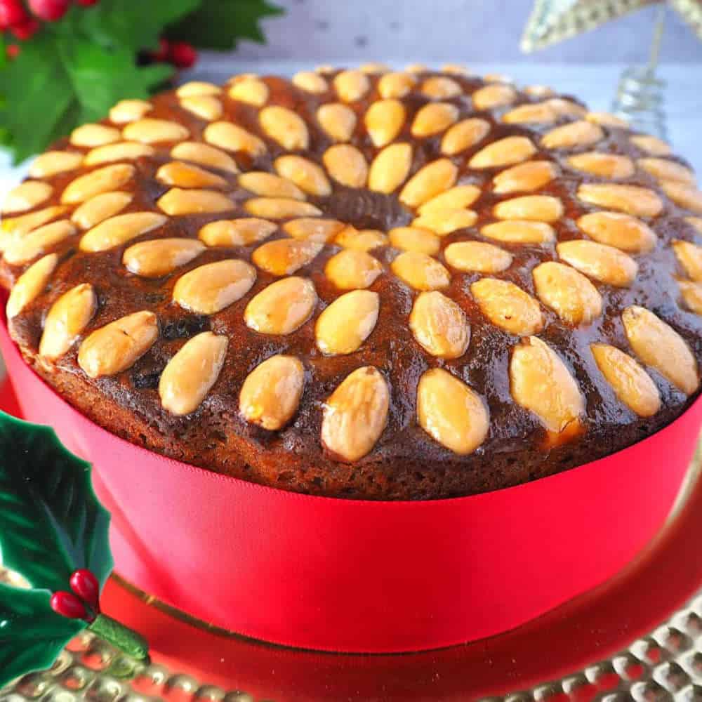 Fruit cake with almond decorations on top.