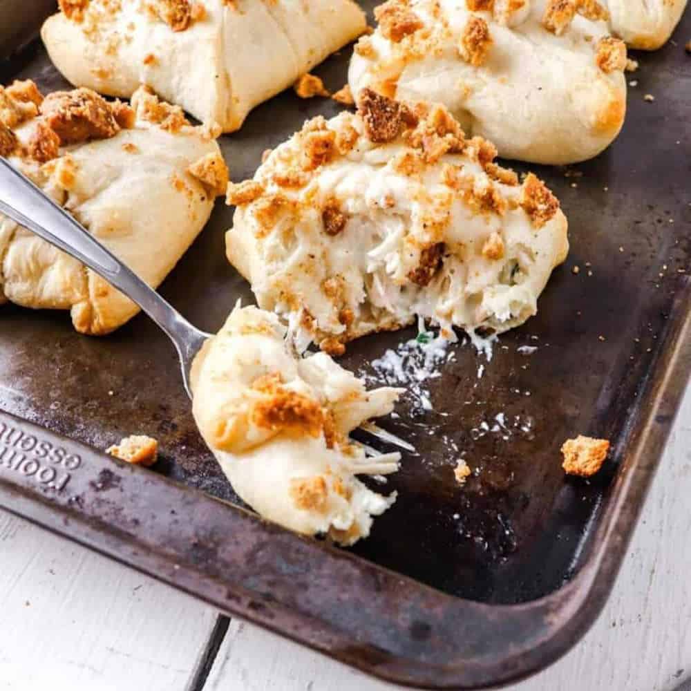 Chicken filled buns on a baking tray.