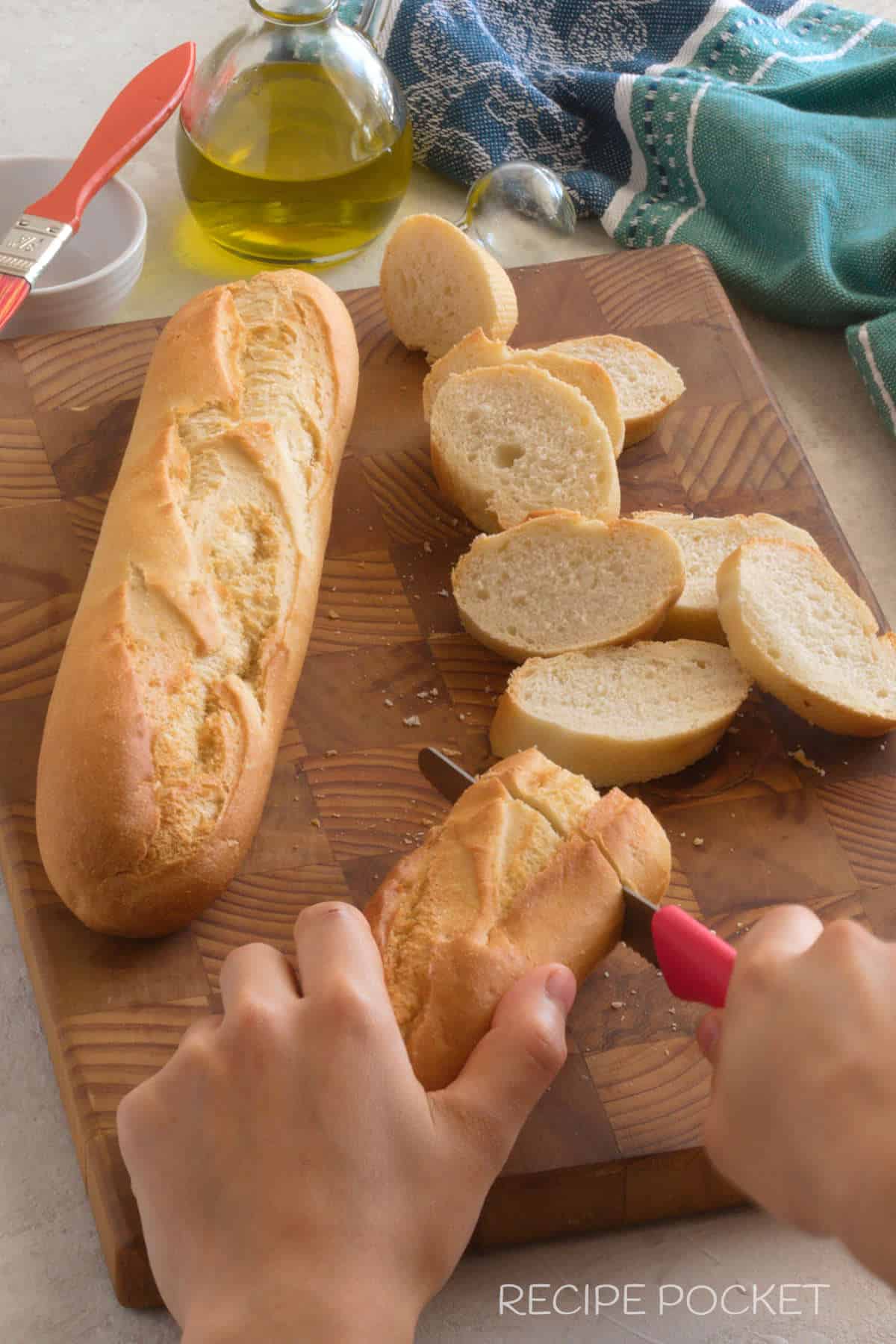 A baguette loaf being cut into slices.