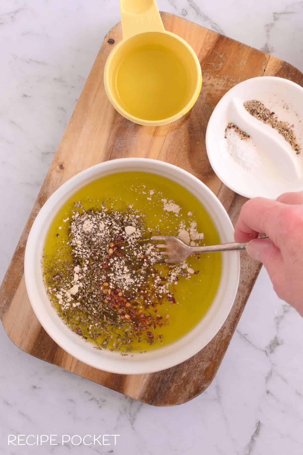 Herbs and seasonings in a bowl of  olive oil.