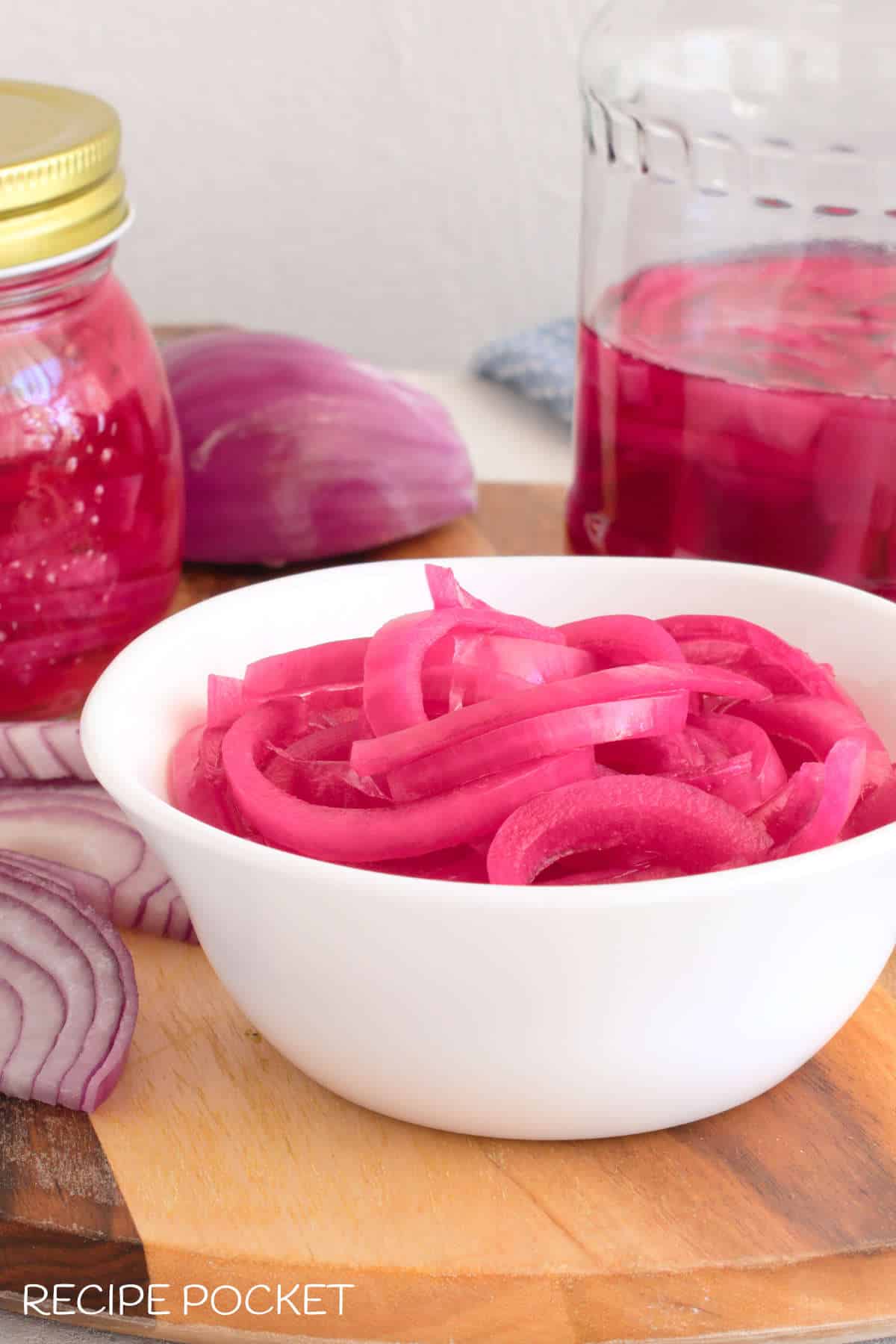 A close up of pink onions in a white bowl.
