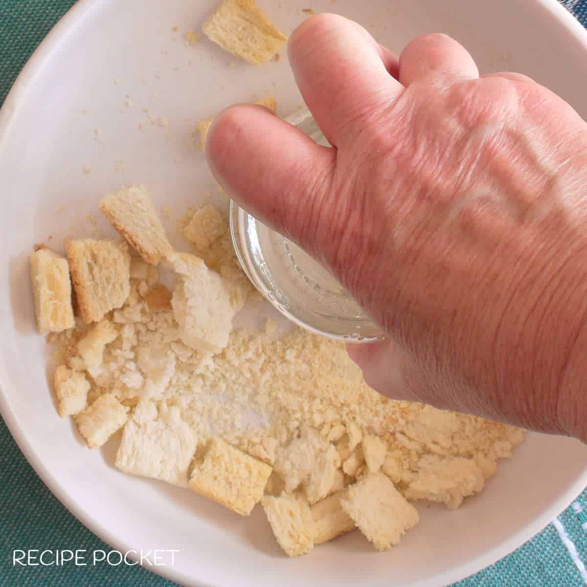 Bread crumbs being crushed by hand.