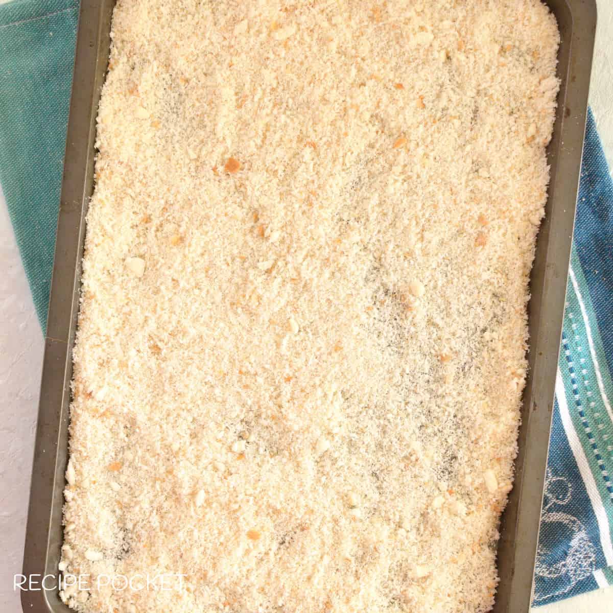 Unbaked bread crumbs on a tray.
