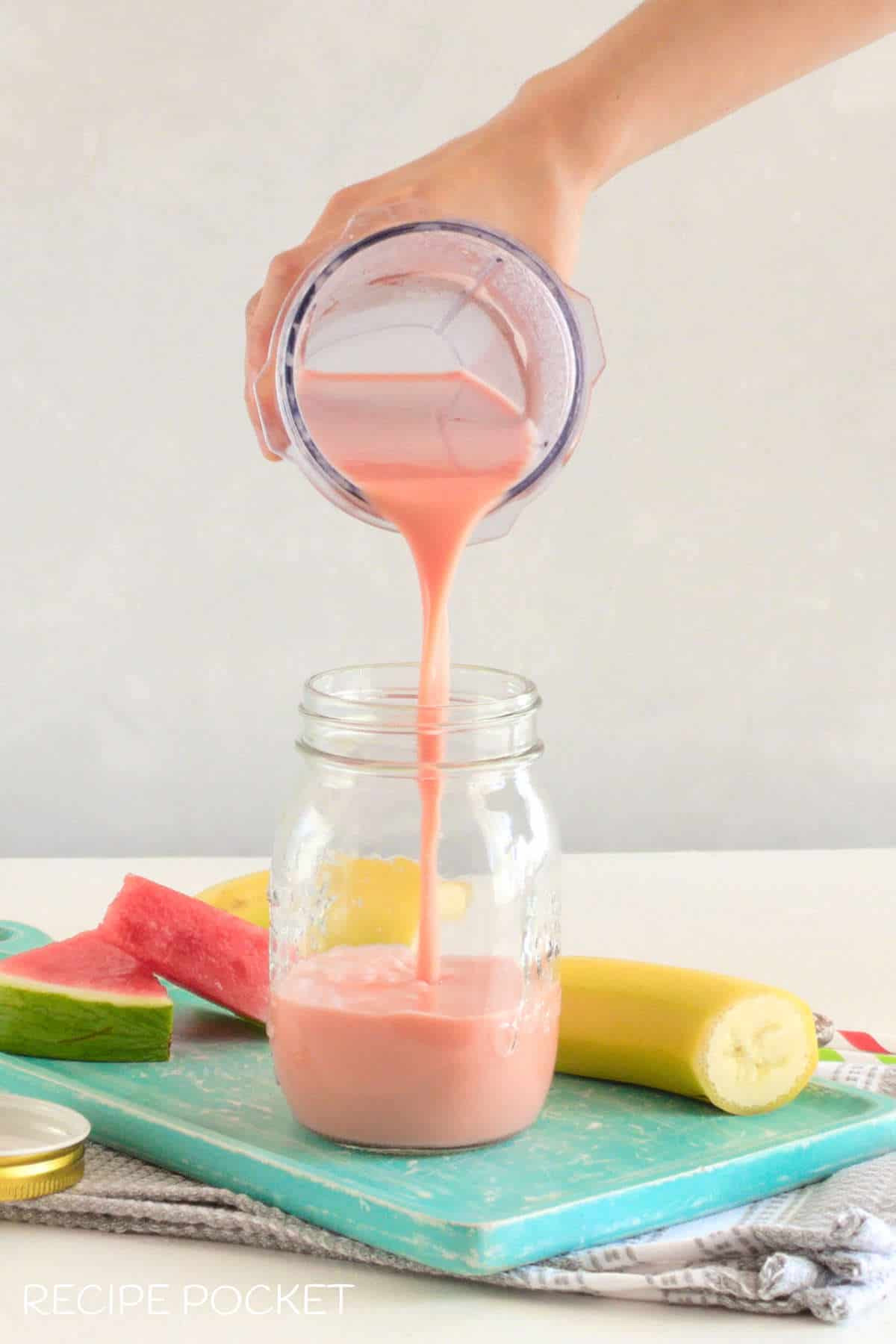 Blended smoothie being poured into a glass.