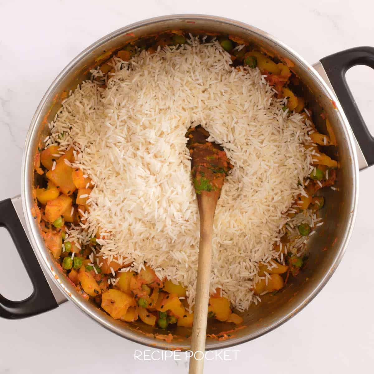 Rice in a pot with cooked vegetables.
