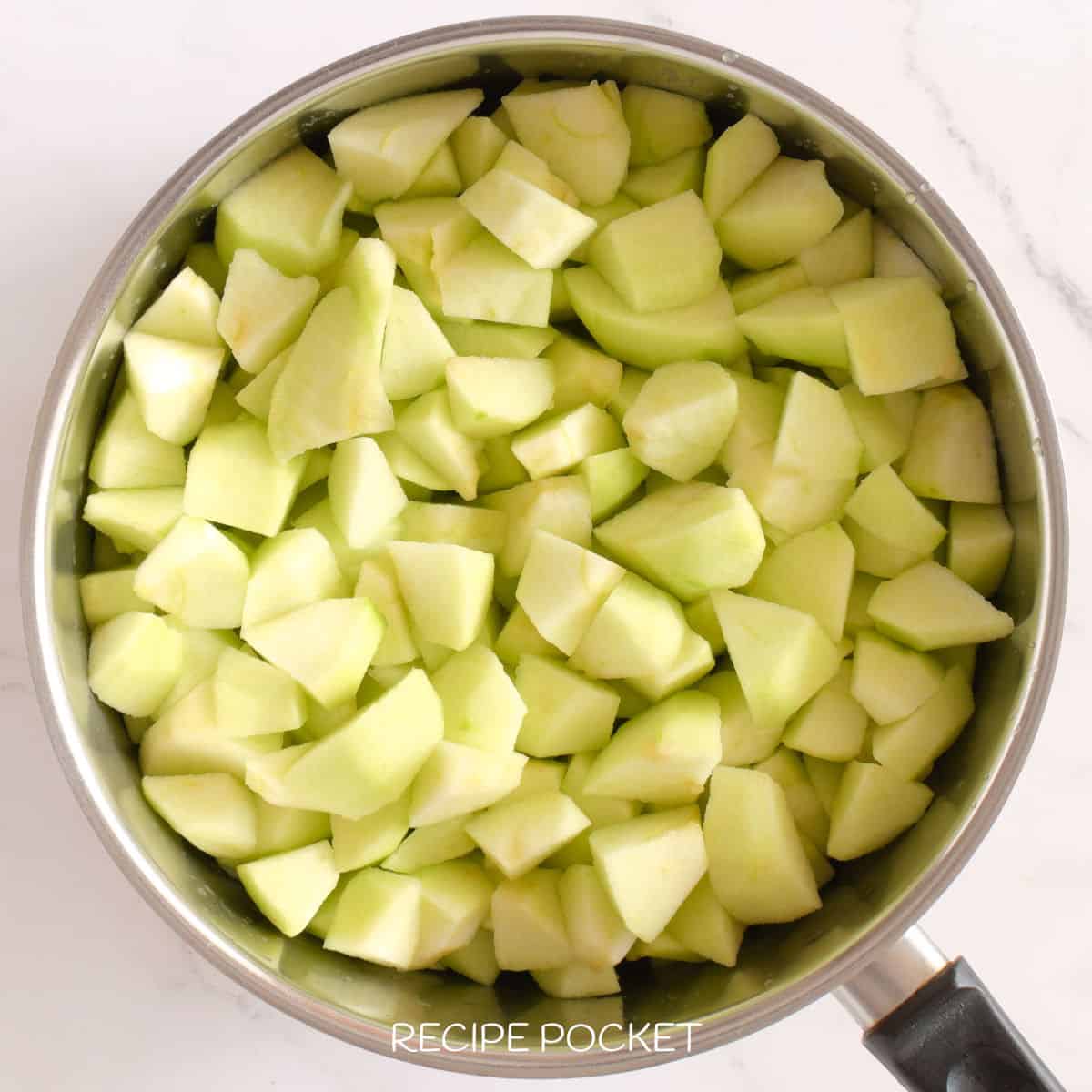 Diced apple pieces in a saucepan.