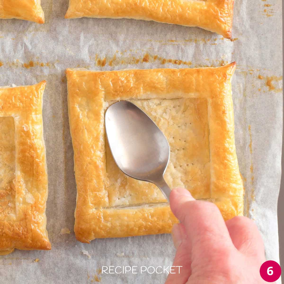 A spoon pressing down the centre of a cooked piece of pastry.