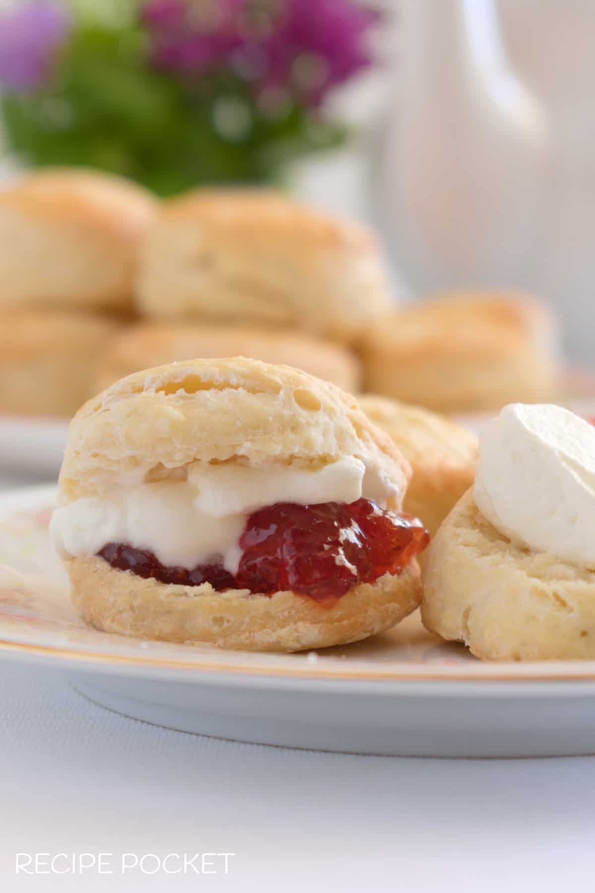 Close up of scones filled with jam and cream.