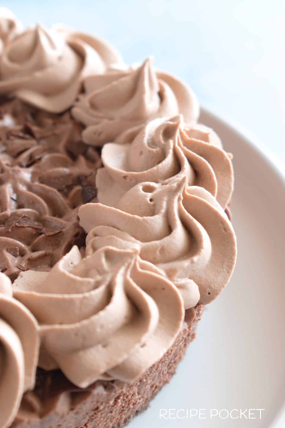 Close up of chocolate cream swirls on a cake.