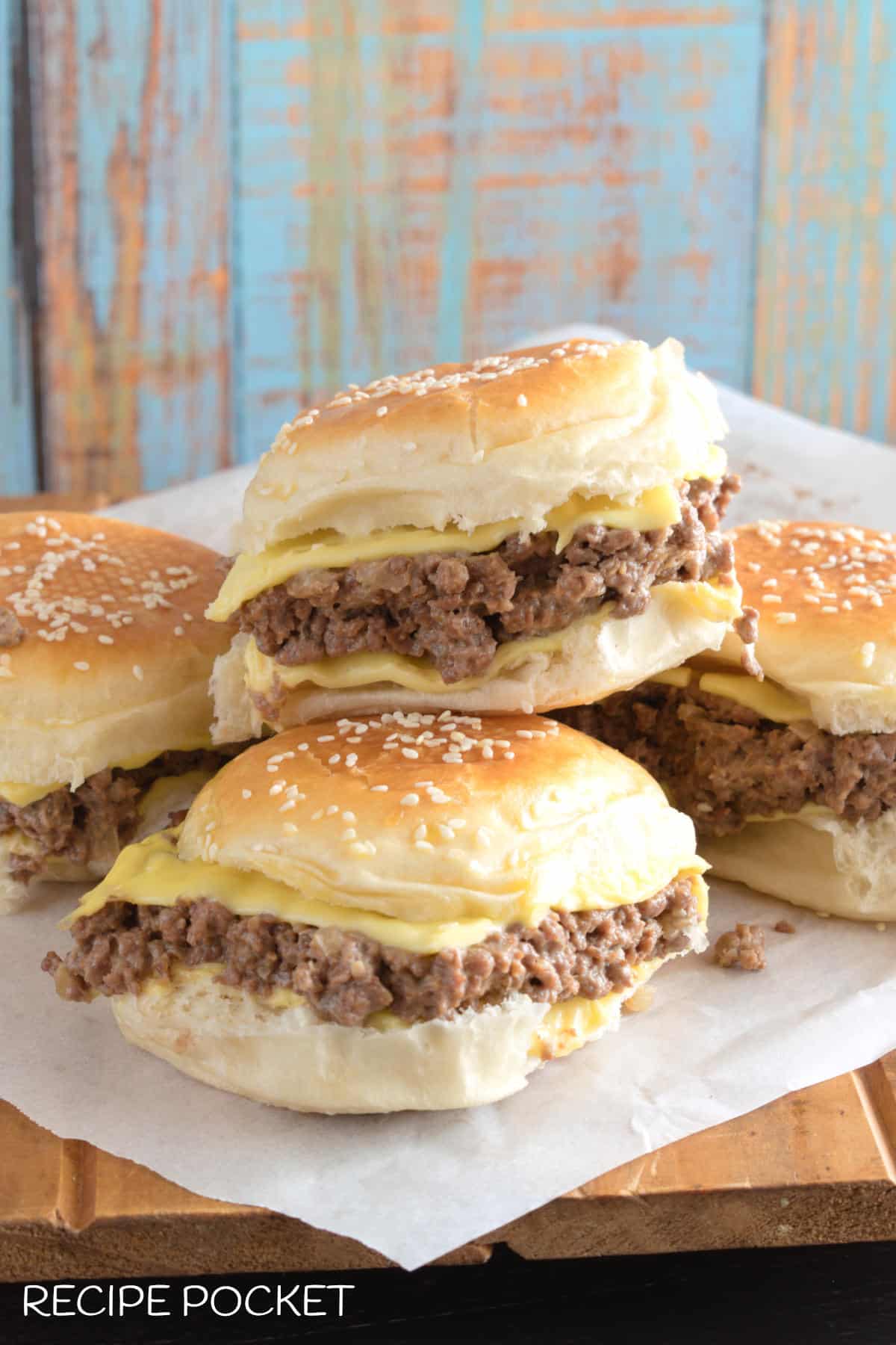 A stack of ground beef  cheese burgers.