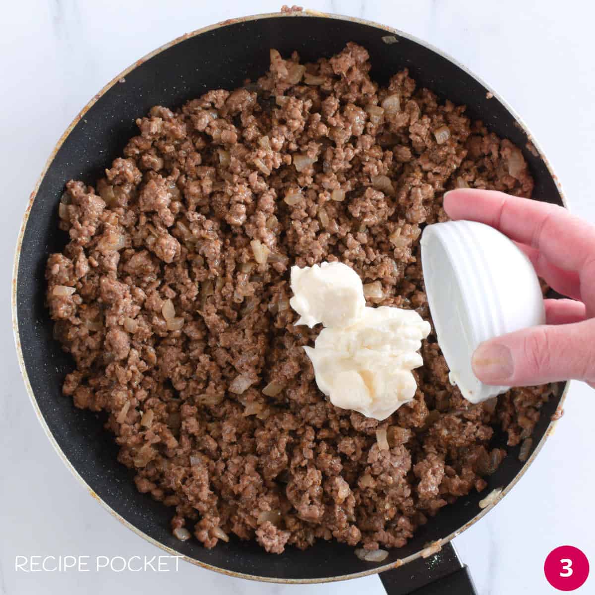 Cooked ground beef and mayonnaise in a pan.
