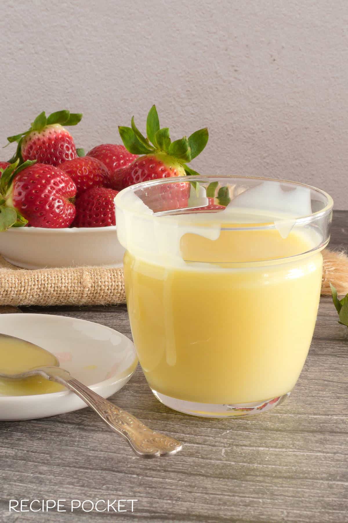 Homemade white chocolate sauce in a glass container.