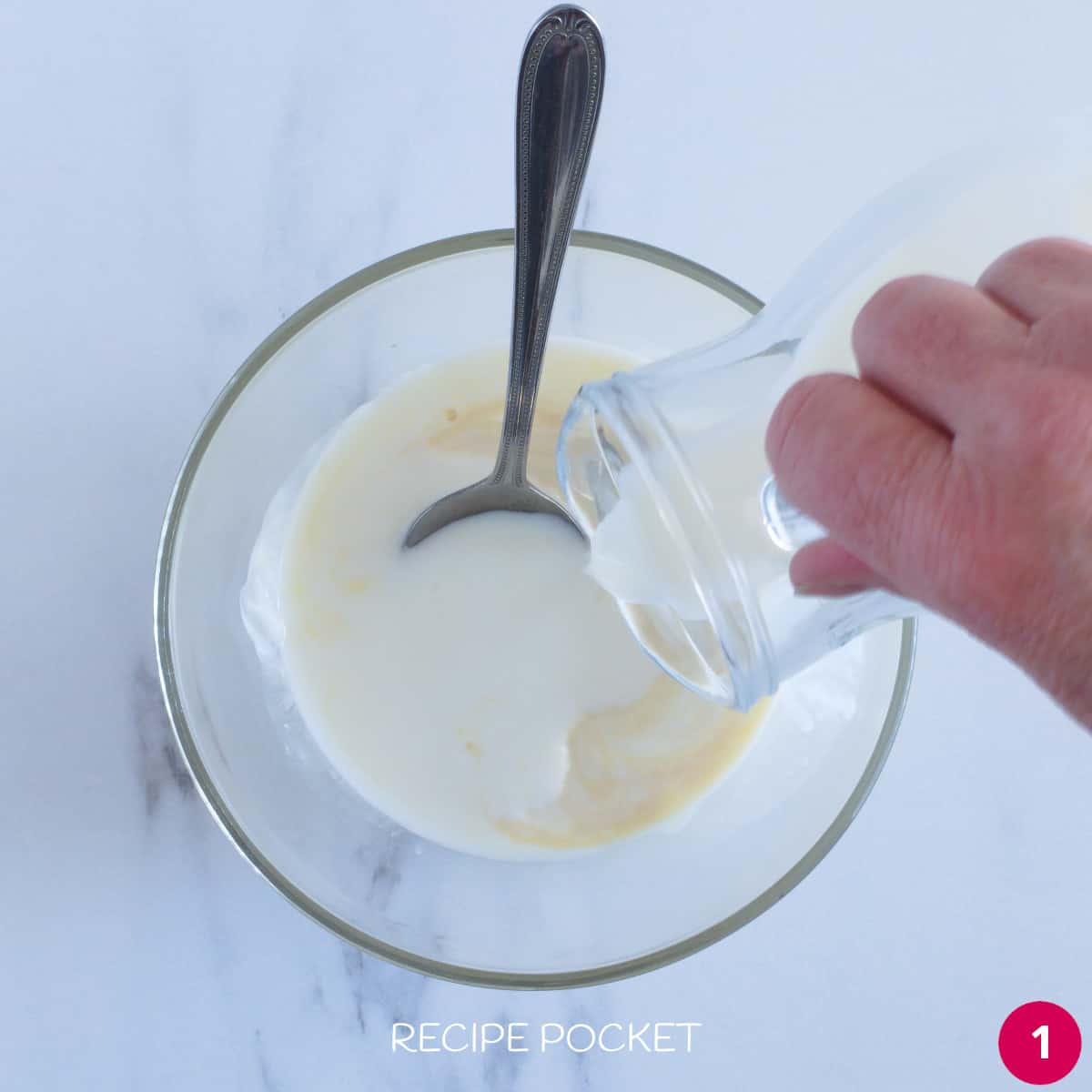Yogurt and milk in a bowl with a spoon.