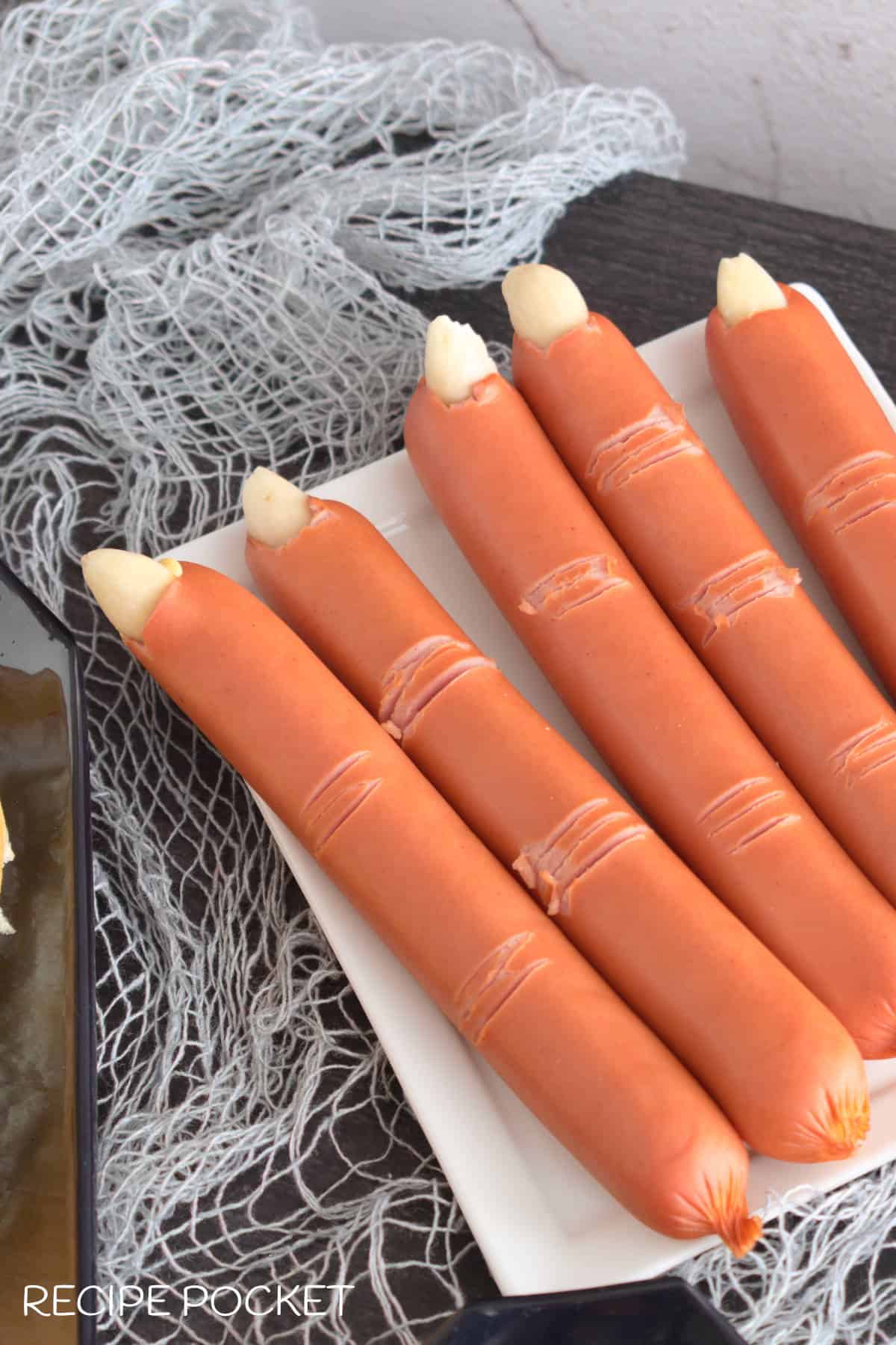 Halloween hot dog fingers on a white plate.