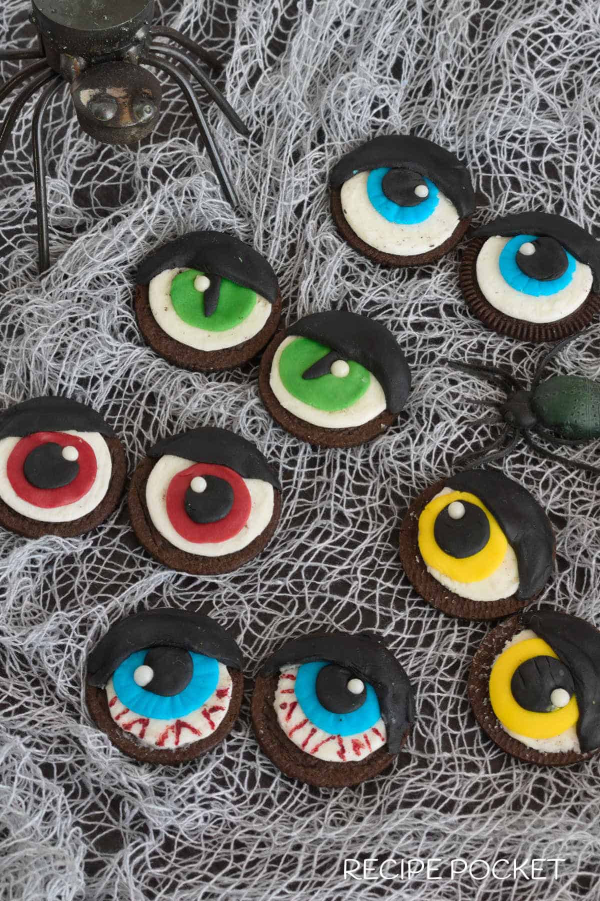 Cookies with plastic spiders on a table.