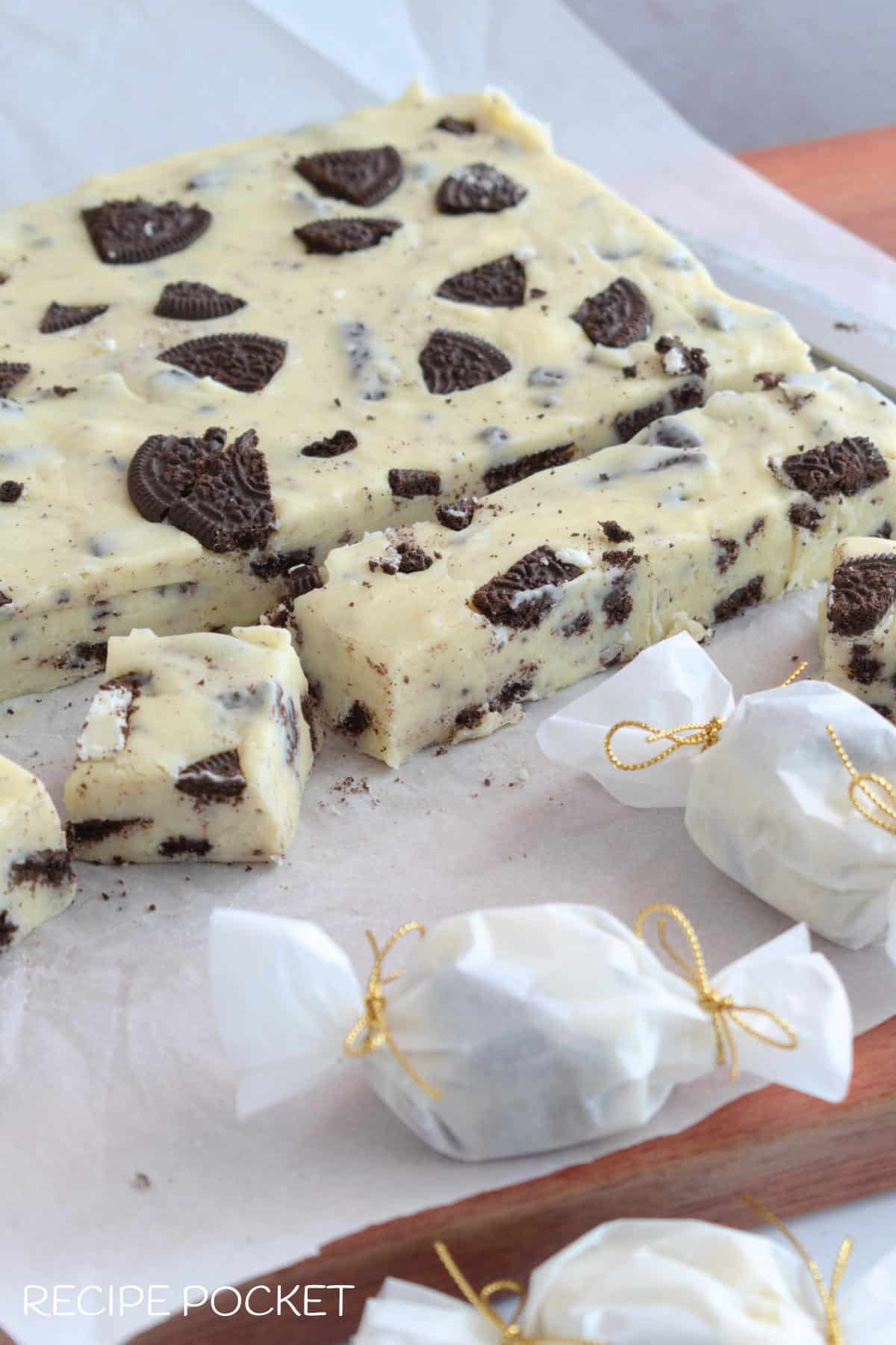 Image showing white chocolate fudge some cut into pieces and some wrapped bon bon style in parchment paper.