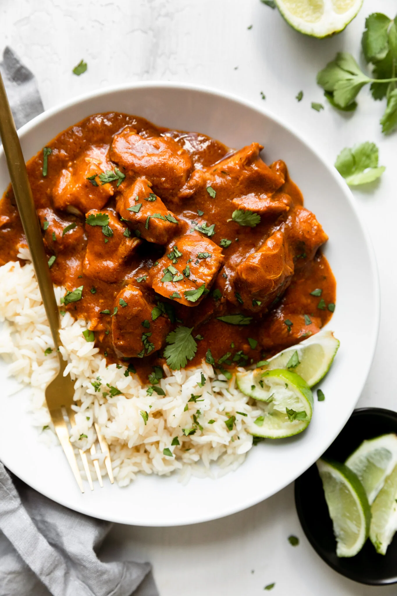 A plate with chicken tikka masala and rice.