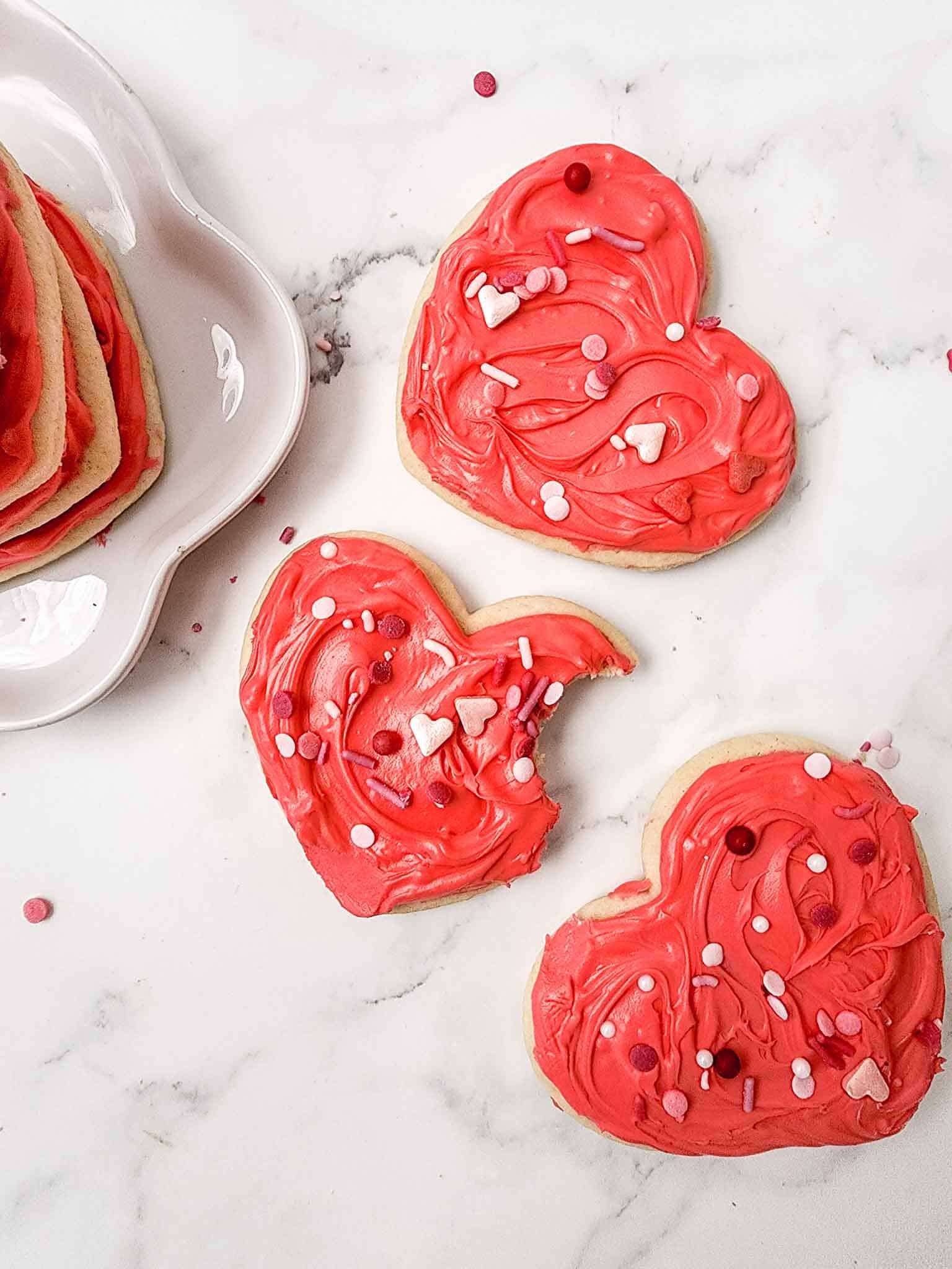 Three red heart shaped cookies.