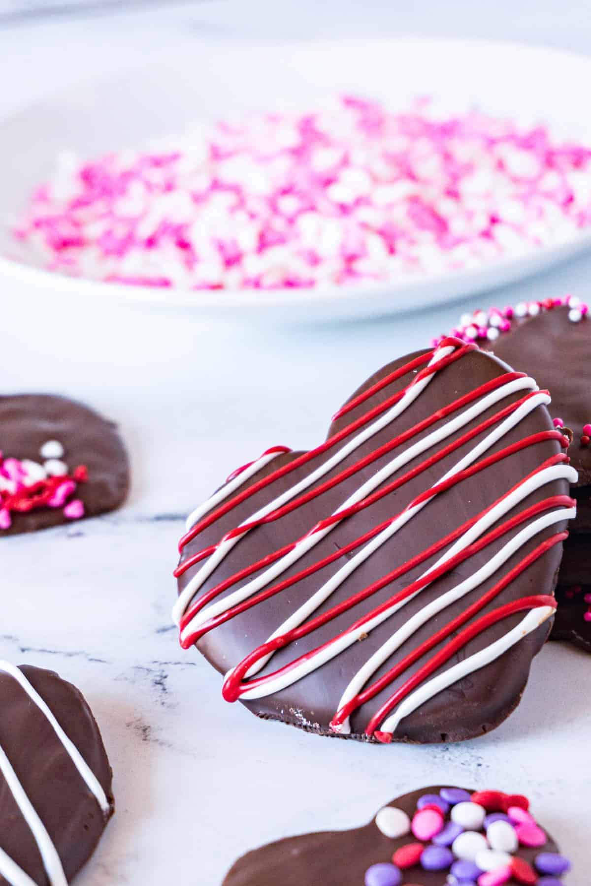 Chocolate covered cherry cookies with white chocolate drizzle decorations.