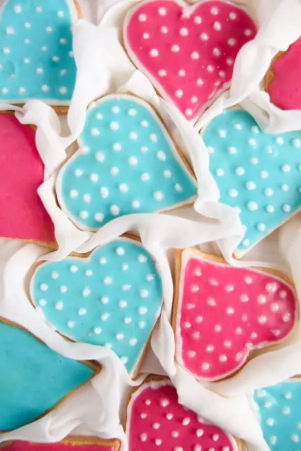 Blue and pink heart cookies with white dots on them.