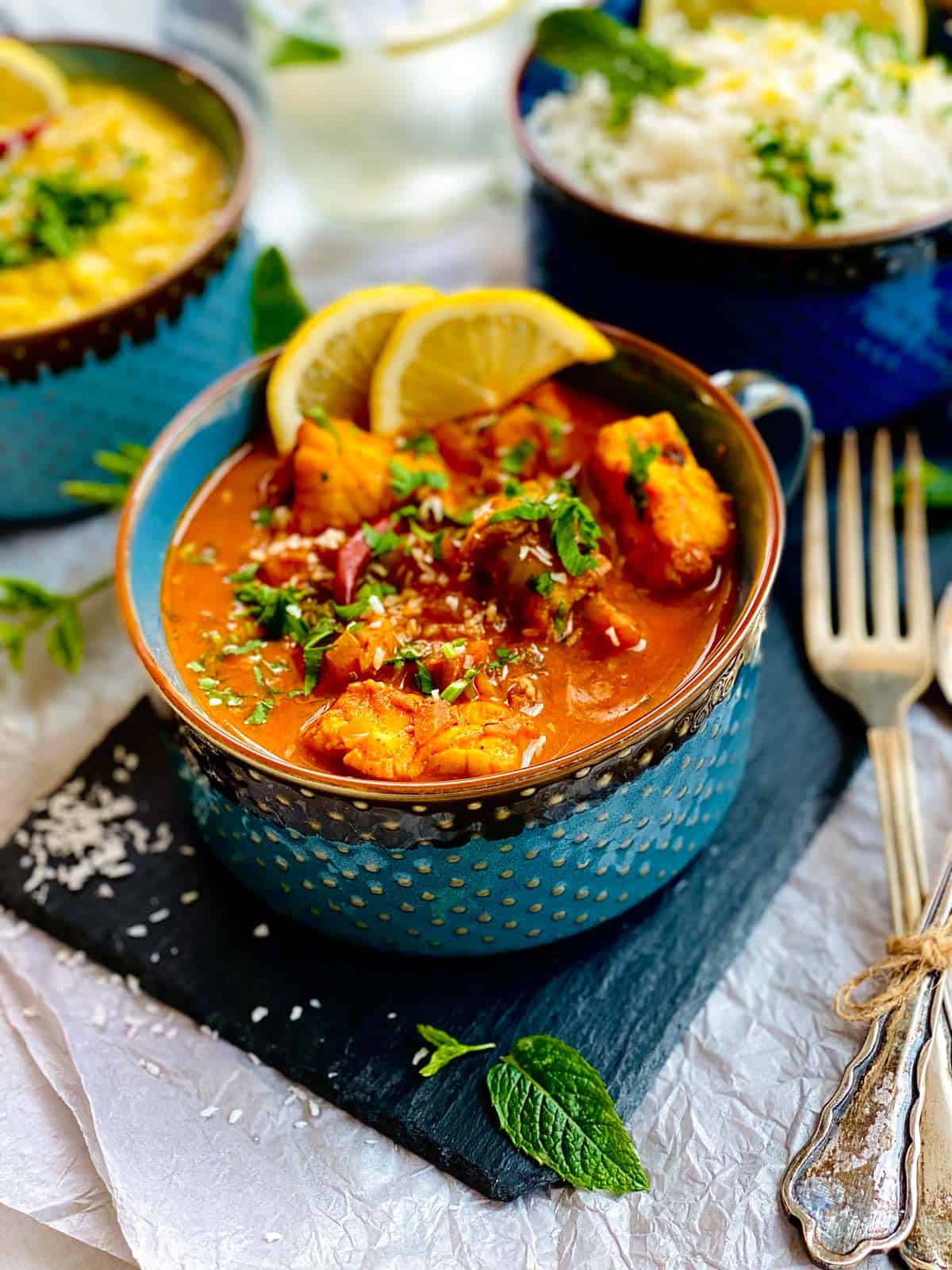 Monkfish curry in blue bowls.