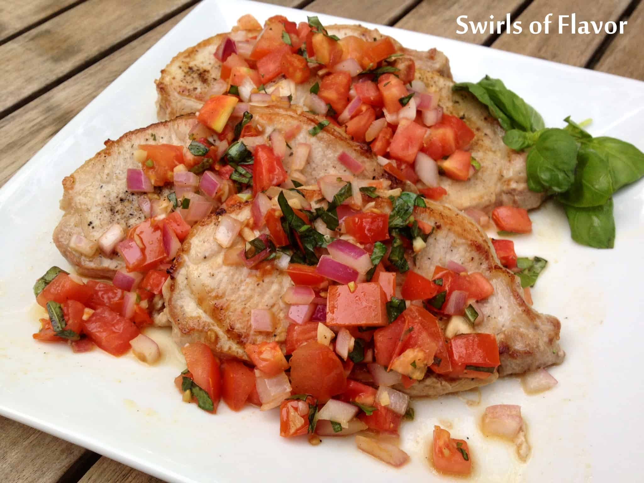 Pork chops with tomato and garlic.