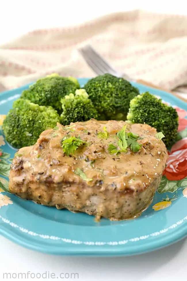 Pork chops with broccoli on a blue plate.