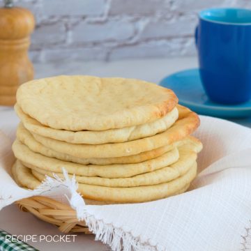 A stack of homemade pita bread on a white cloth.
