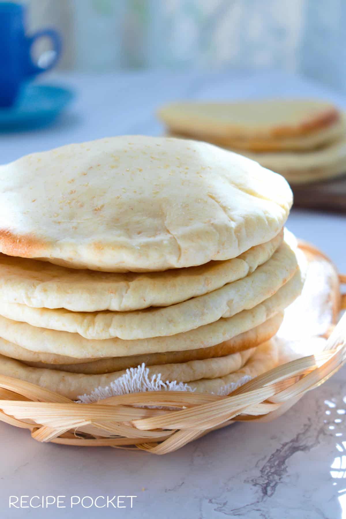 A stack of homemade pita bread on a table.